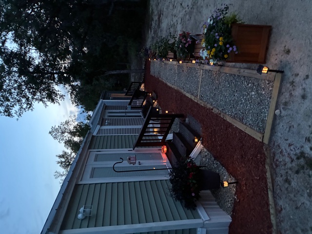 Cottage entries and path lights along the lodging walkway at dusk.