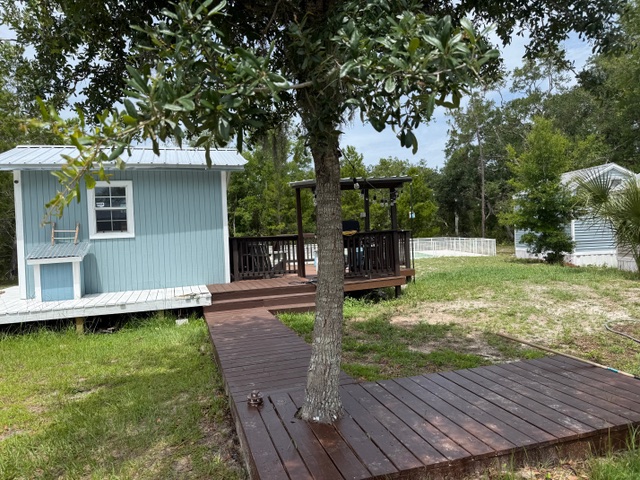 Retreat grounds with cottages, deck paths, tree shade, and sandy grass.
